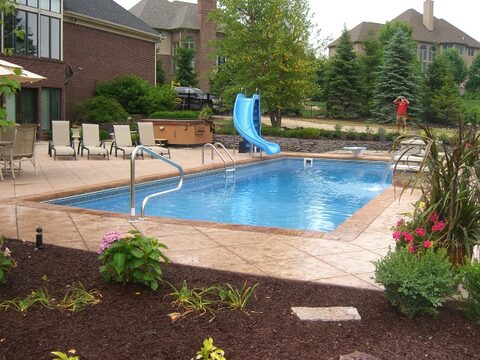 Monaco fiberglass pool — a real B Cool Pools install with stamped concrete deck.